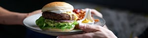 Burger on a plate with a black background