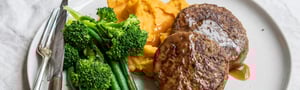 Angel Bay beef rissoles on a plate with sweet potato mash, beans and broccoli